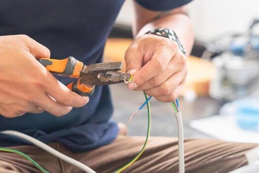 Services technician man connecting electric wires with pliers to install new air conditioning repair service and install new air conditioner concepts photo